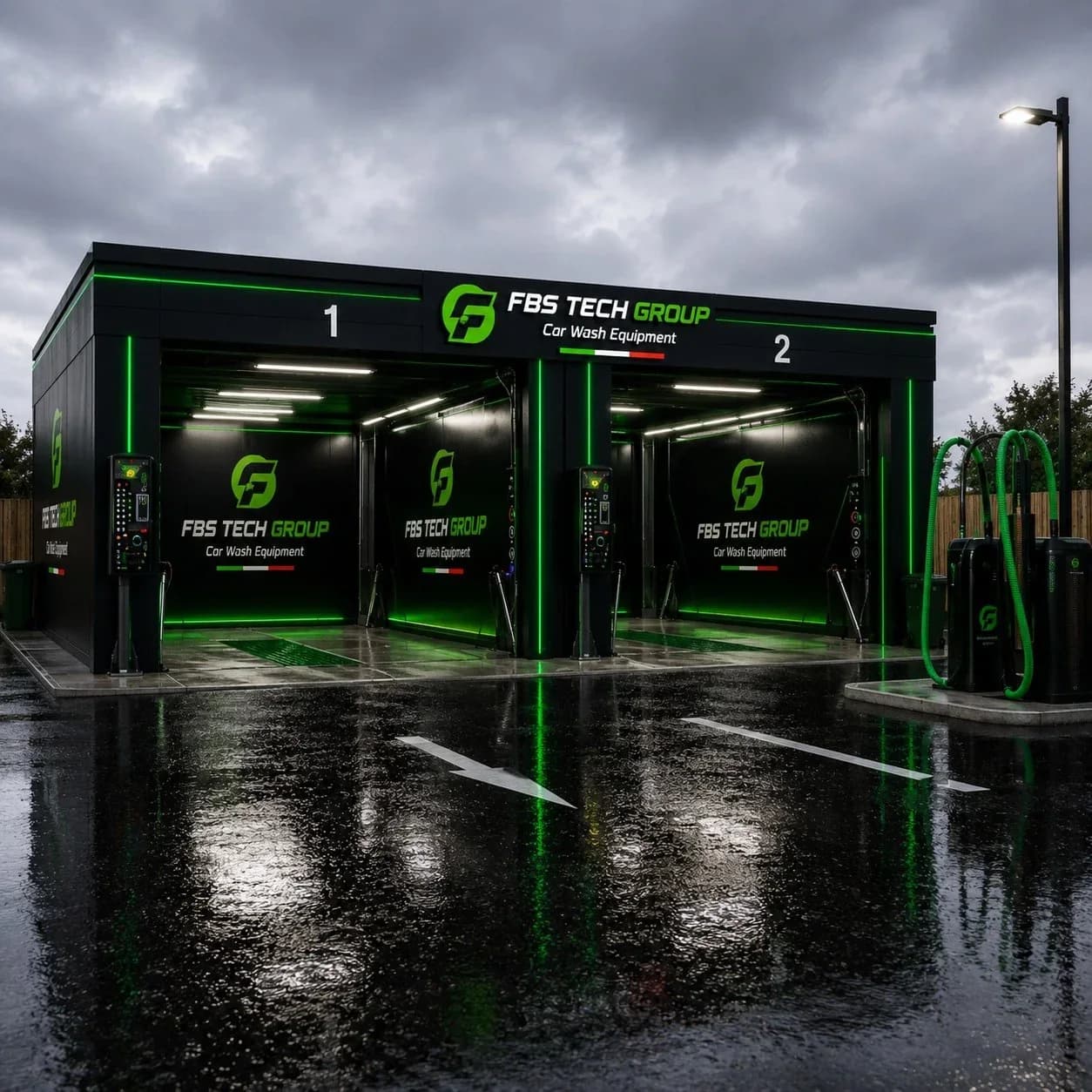 A two-bay FBS Tech Group station at night, green LED uprights reflected across wet asphalt under a heavy sky